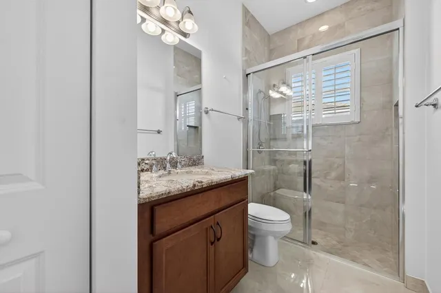 an empty room with chandelier fan and windows