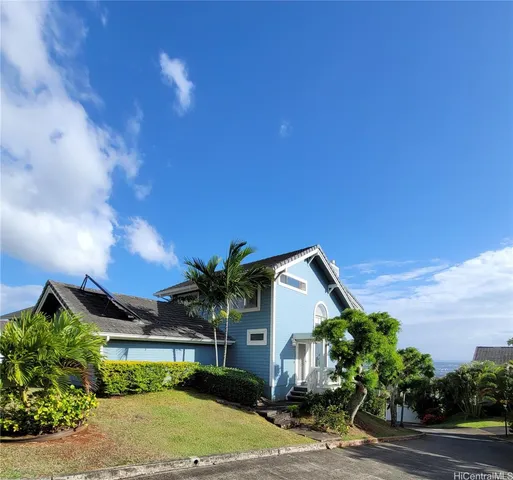 a front view of a house with a yard and mountain view