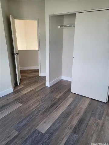 an empty room with wooden floor and entrance