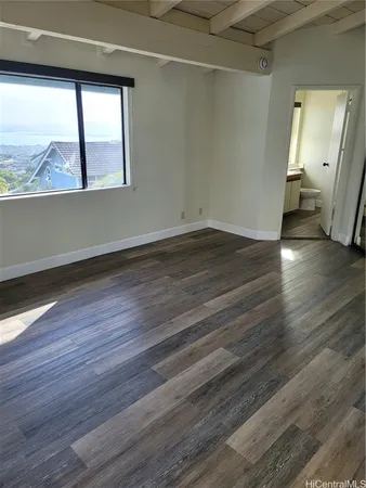 a view of empty room with wooden floor and outdoor view