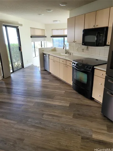 a kitchen with stainless steel appliances kitchen island granite countertop a stove a sink and a microwave