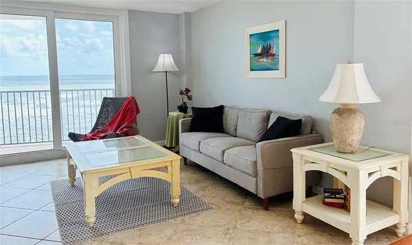 a living room with furniture a flat screen tv and a floor to ceiling window