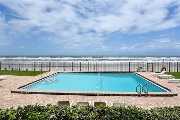 a view of an apartment with a swimming pool and a yard