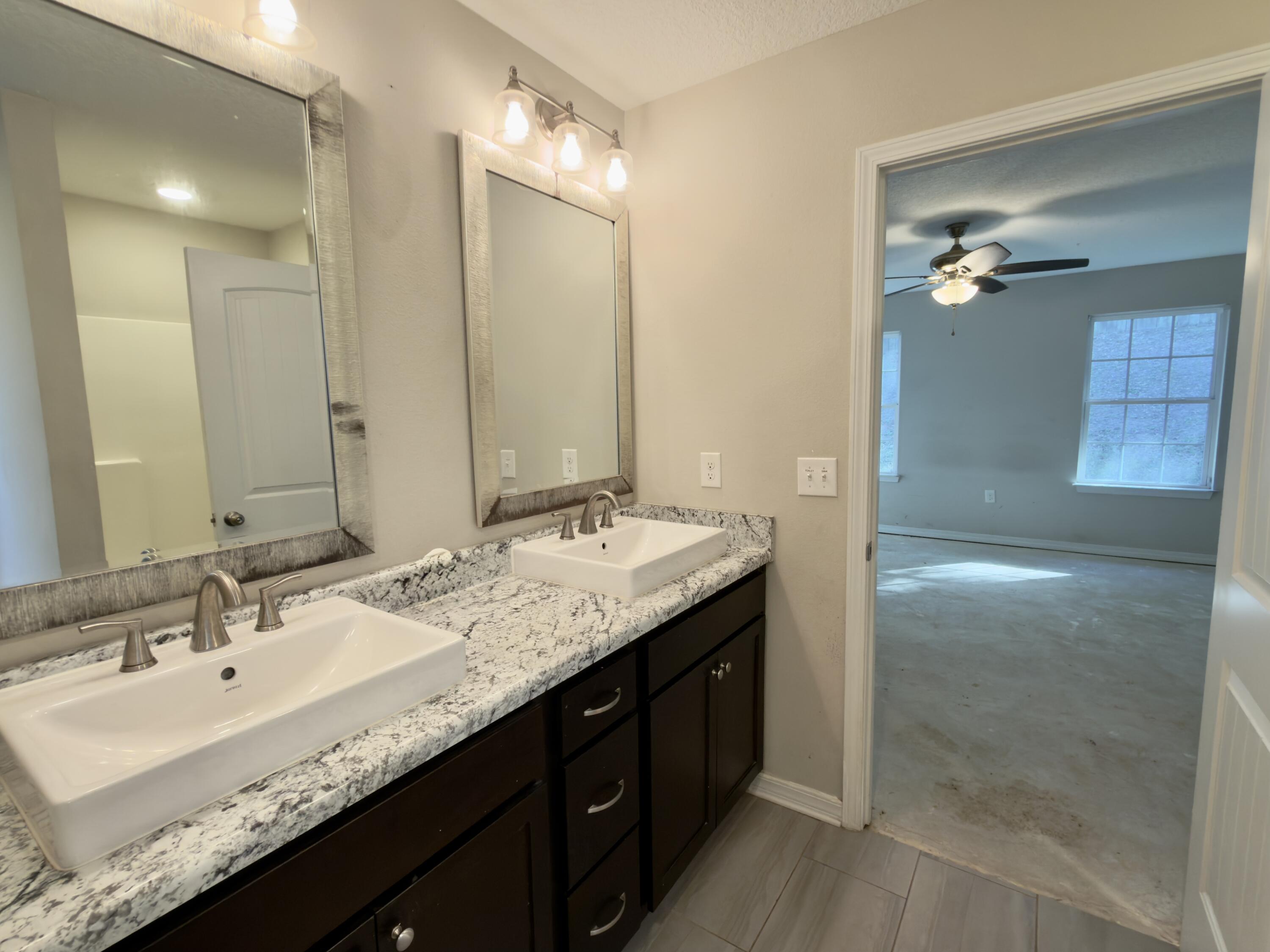 201 Wainwright Drive Crestview, FL 32539 - Photo 11 of 26 a bathroom with a granite countertop sink double vanity and a mirror