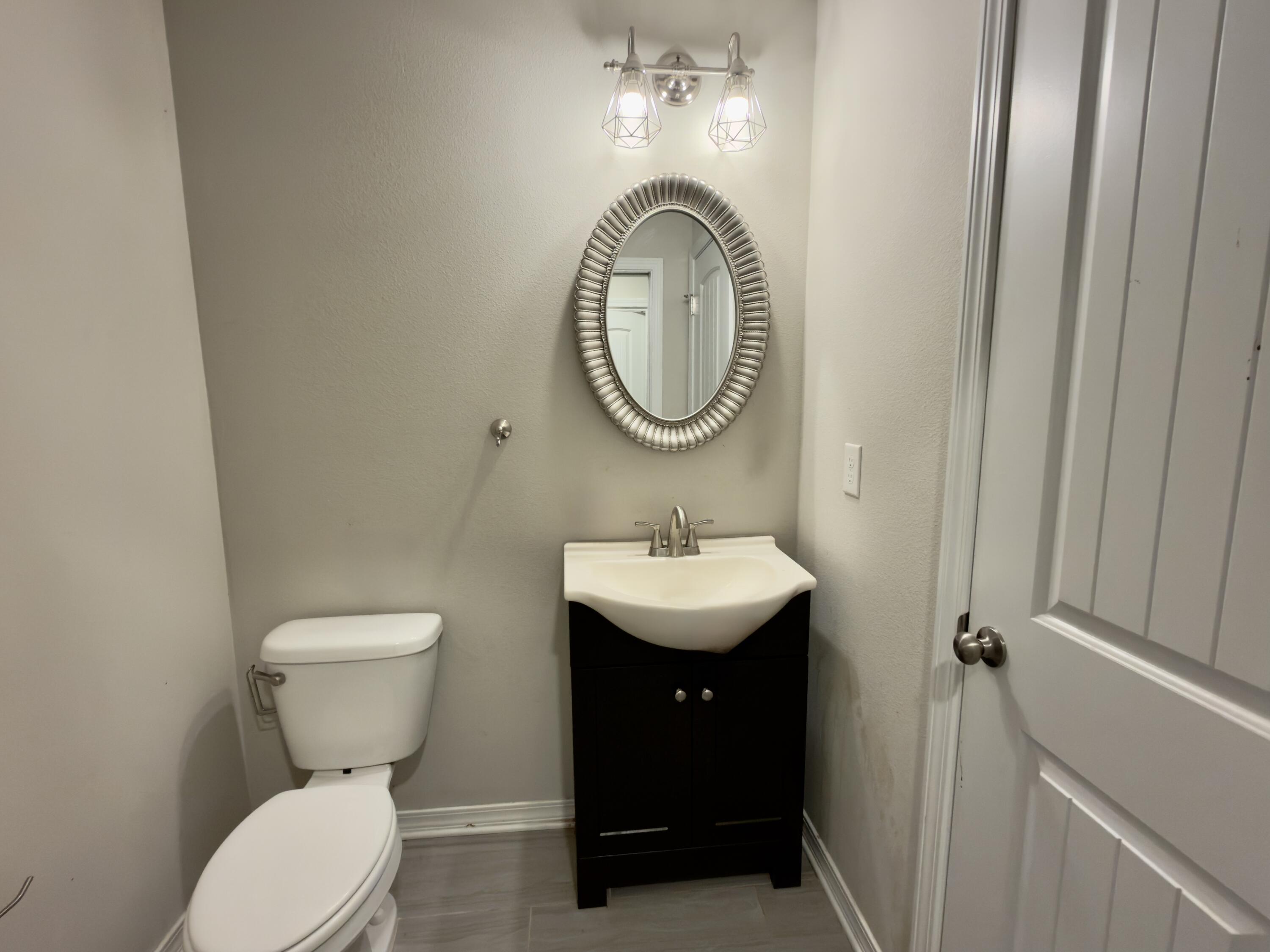 201 Wainwright Drive Crestview, FL 32539 - Photo 12 of 26 a bathroom with a toilet sink and mirror