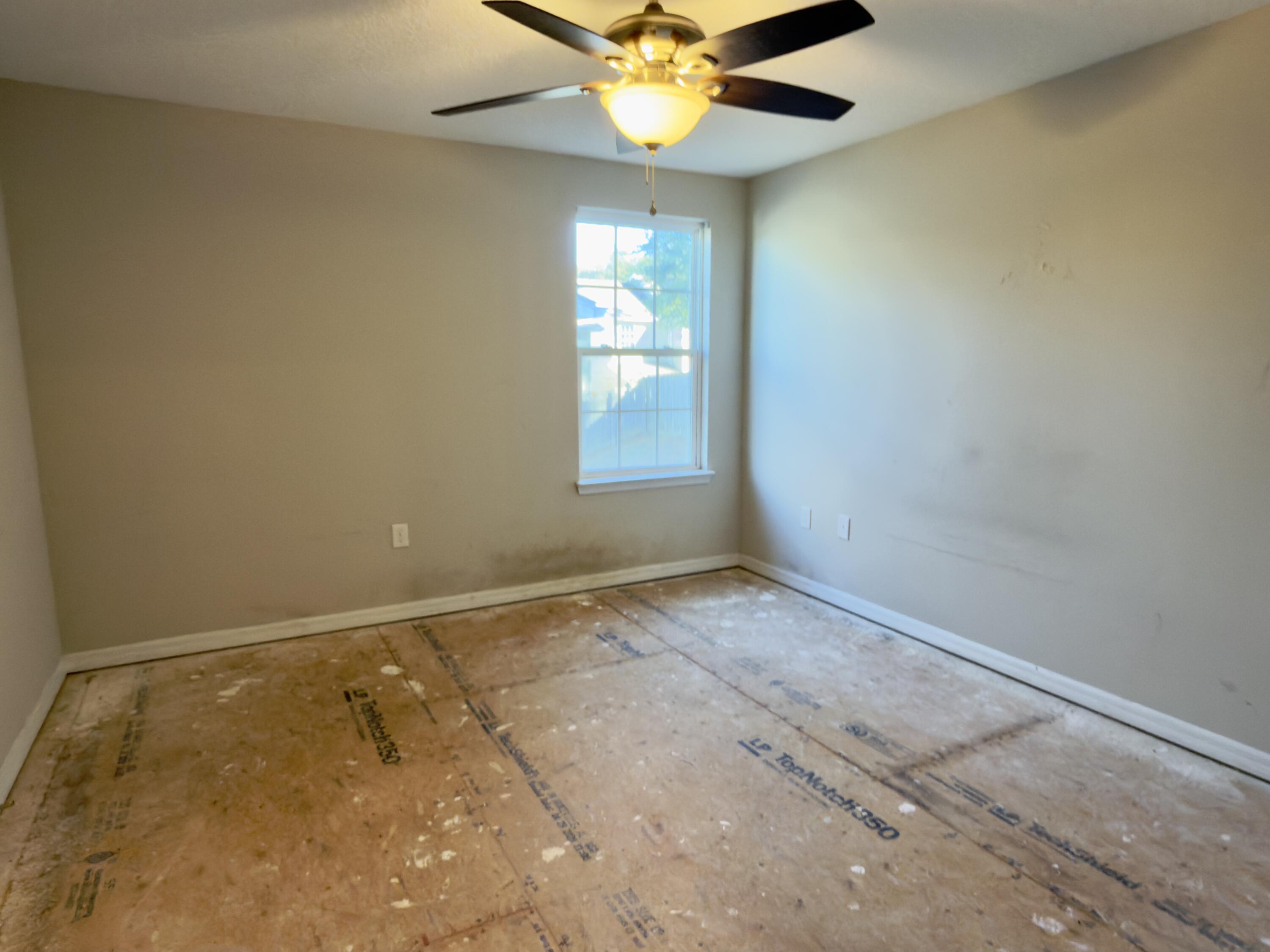 201 Wainwright Drive Crestview, FL 32539 - Photo 15 of 26 en empty room with windows and fan