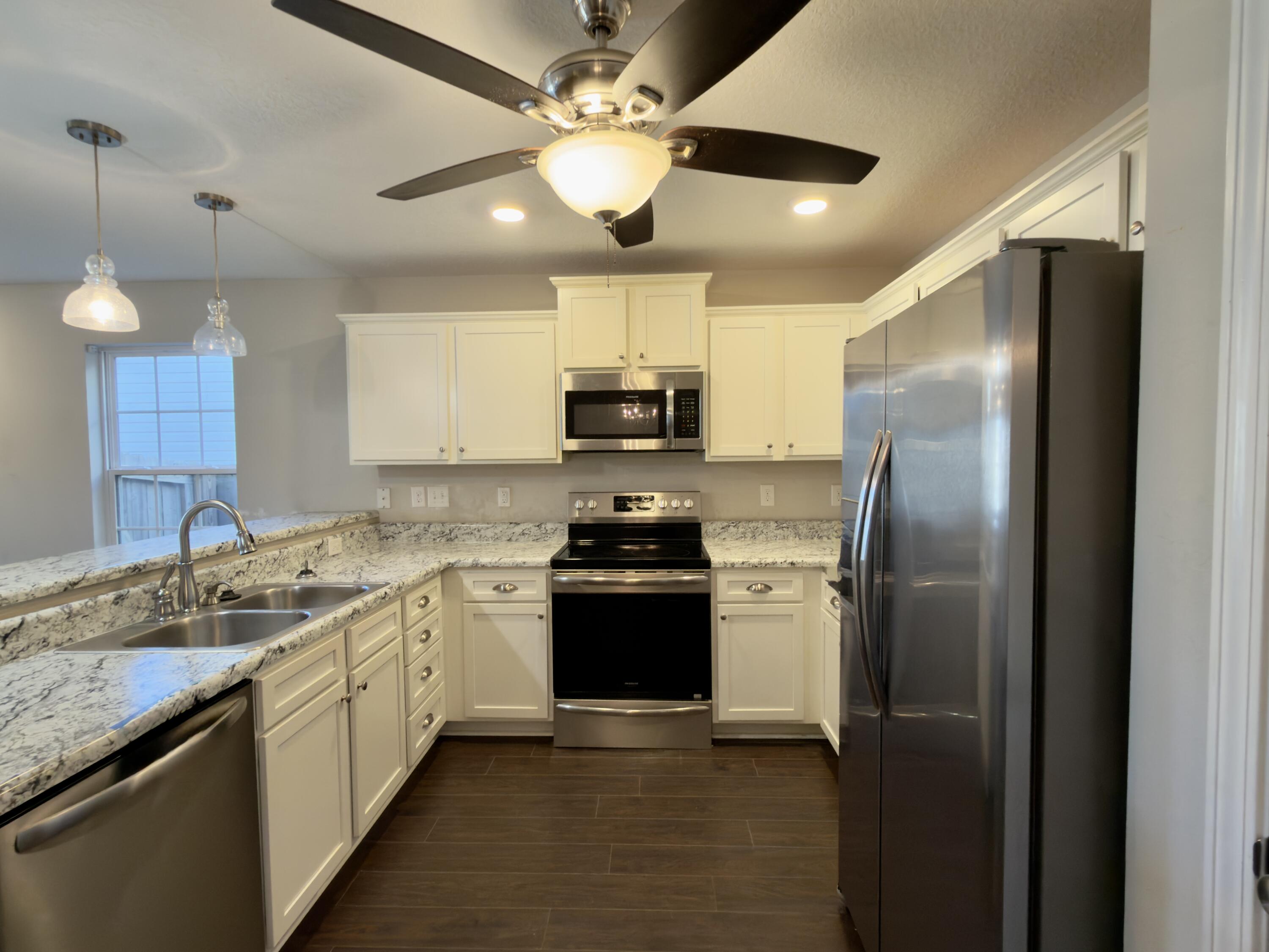 201 Wainwright Drive Crestview, FL 32539 - Photo 5 of 26 a kitchen with a stove sink and refrigerator
