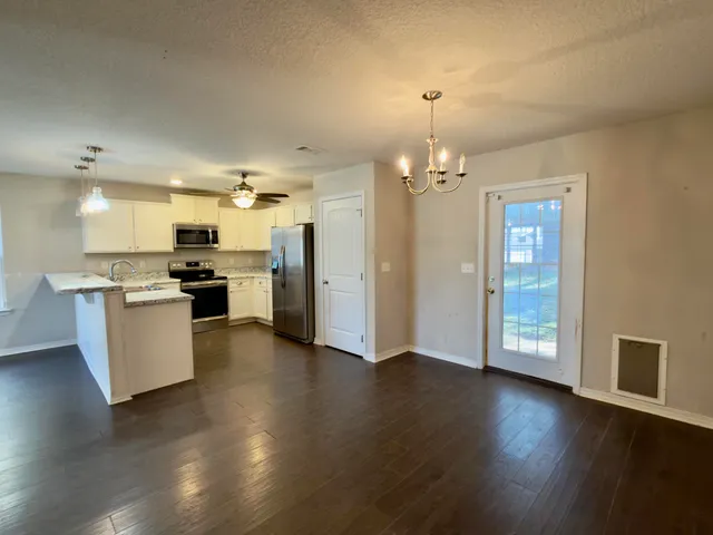 a view of a kitchen with furniture and wooden floor