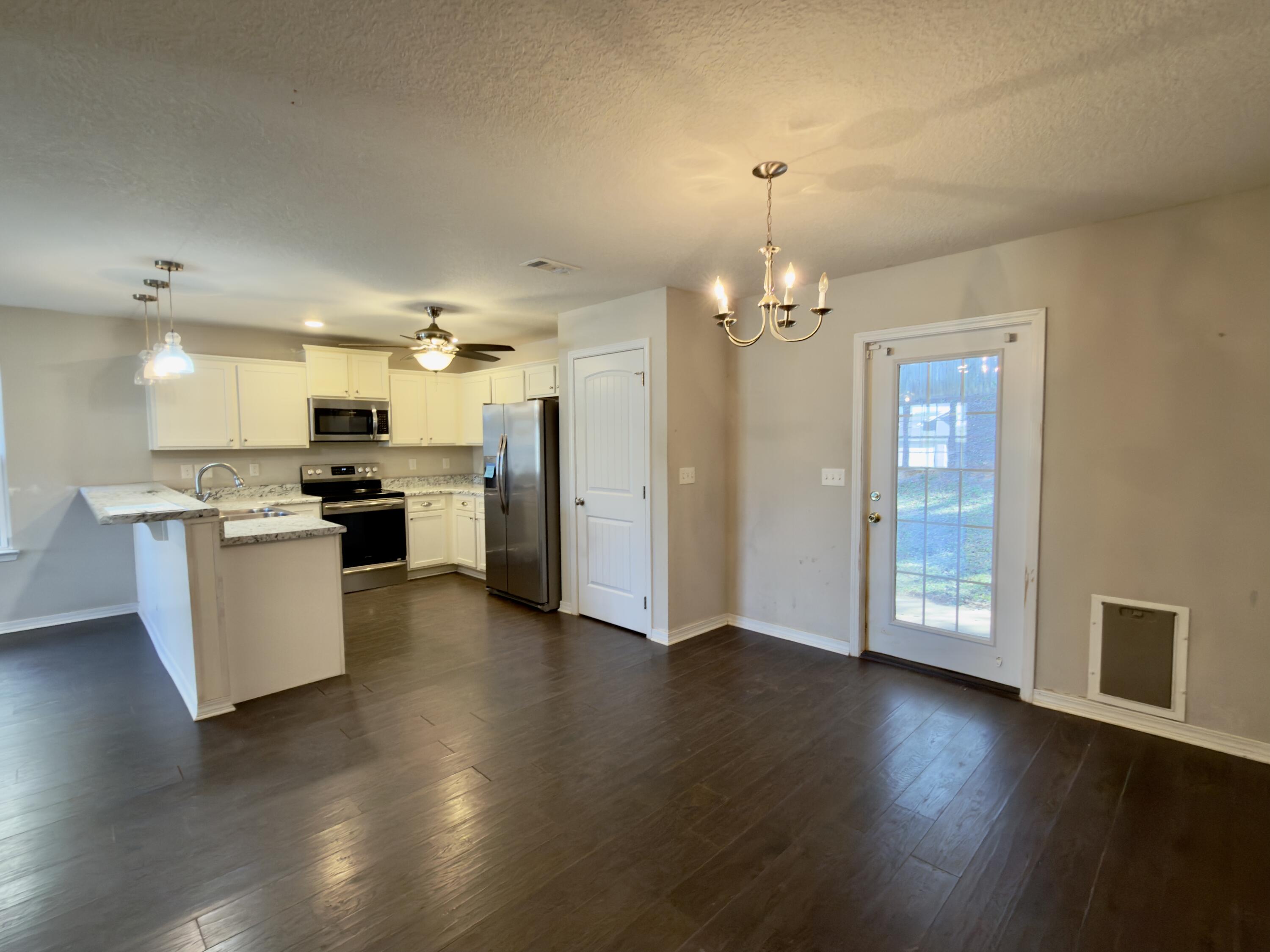 201 Wainwright Drive Crestview, FL 32539 - Photo 6 of 26 a view of a kitchen with furniture and wooden floor
