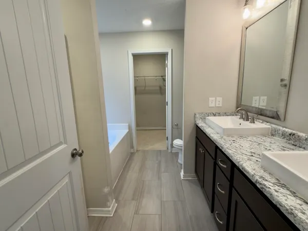 a bathroom with a granite countertop sink a mirror and a shower