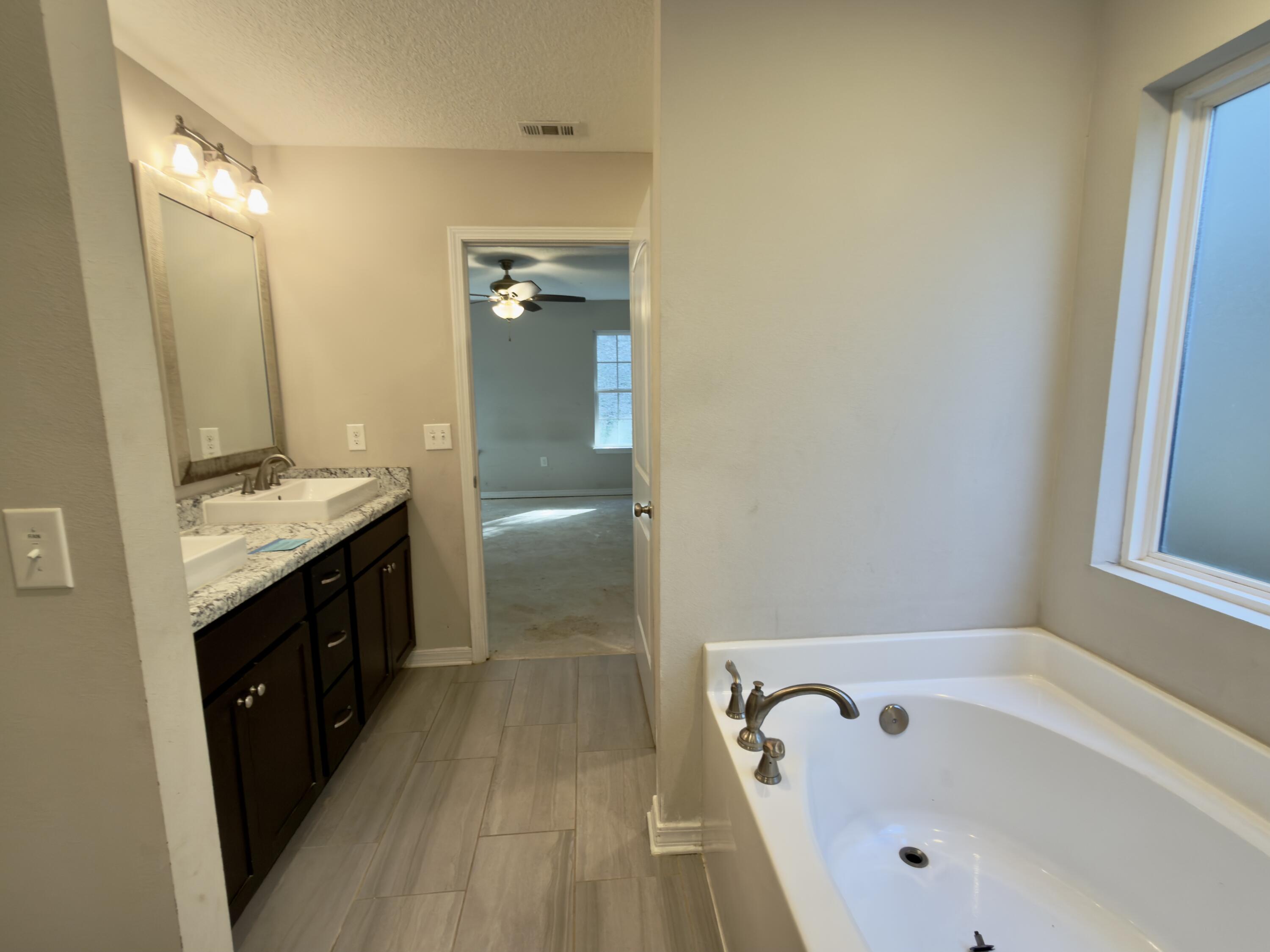 201 Wainwright Drive Crestview, FL 32539 - Photo 10 of 26 a spacious bathroom with a granite countertop tub sink and mirror