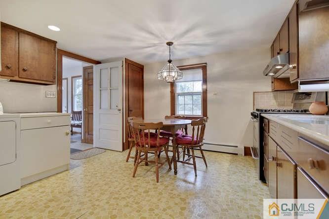 963 Ridge Road Princeton, NJ 08540 - Photo 12 of 25 a dining room with furniture a chandelier a kitchen view and a window