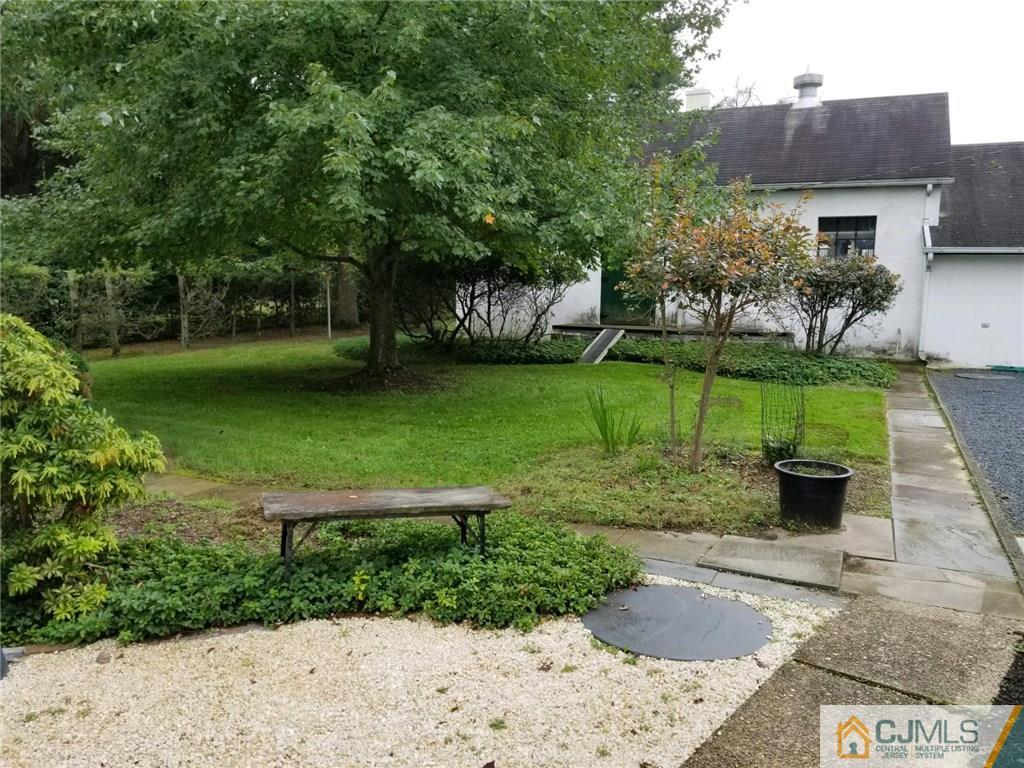 963 Ridge Road Princeton, NJ 08540 - Photo 17 of 25 a view of a garden with a bench in front of the house