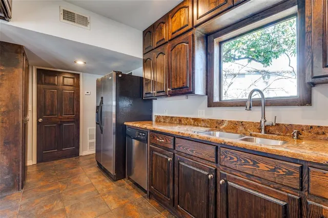 a kitchen with stainless steel appliances granite countertop a refrigerator and a sink