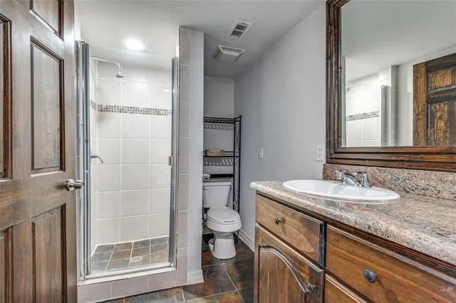 a bathroom with a granite countertop sink toilet and shower