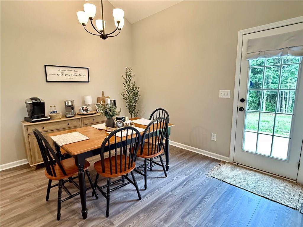 1776 Pleasant Grove Road Temple, GA 30179 - Photo 15 of 45 a dining room with wooden floor a chandelier a wooden table and chairs