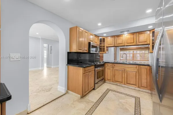 a kitchen with stainless steel appliances granite countertop a stove a sink and a refrigerator