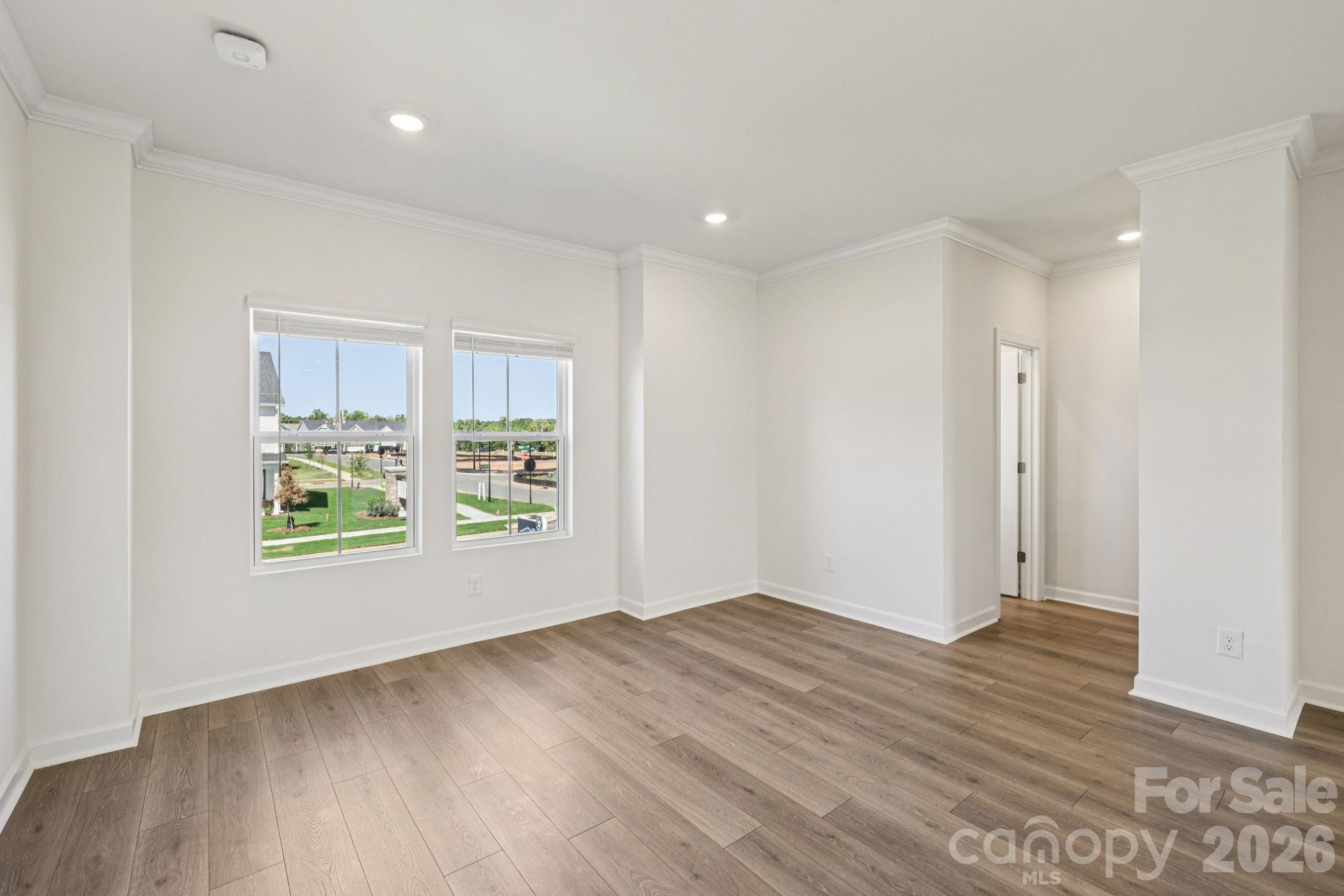 335 Golden Maple Court Fort Mill, SC 29708 - Photo 21 of 26 an empty room with wooden floor and windows