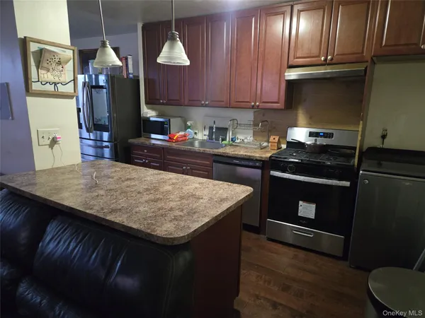 a kitchen with kitchen island granite countertop wooden cabinets and a sink