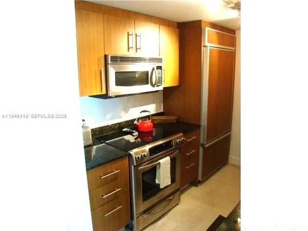 a kitchen with stainless steel appliances granite countertop a stove and a microwave