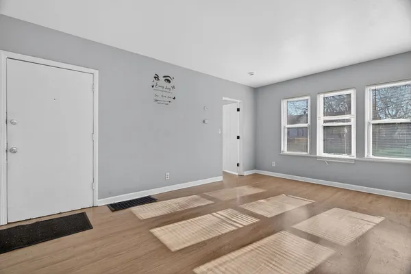 a view of a bedroom with a bed and wooden floor