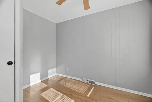 a view of a livingroom with wooden floor and kitchen space