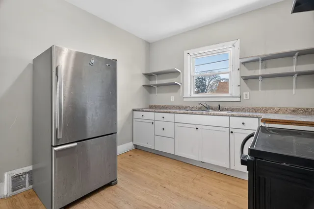 a walk in closet with wooden floor