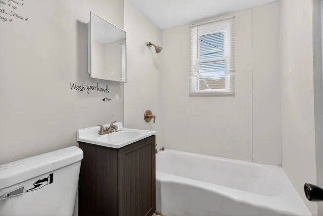 a view of a room with wooden floor and a ceiling fan