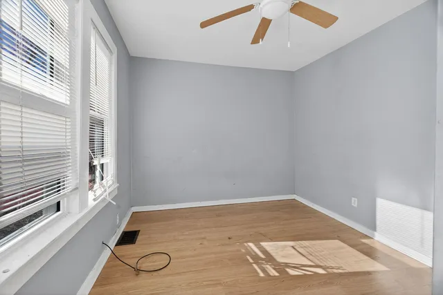 a view of a room with wooden floor and windows