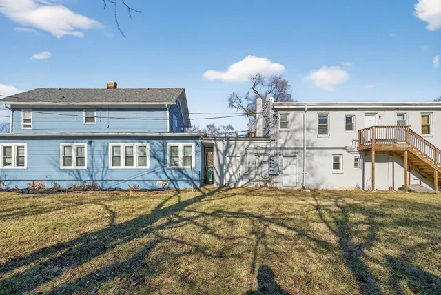 a view of a house with a big yard and a large tree