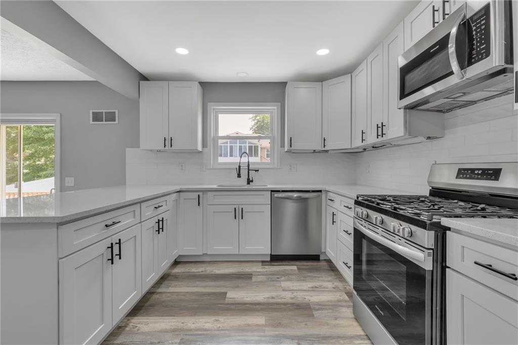 1301 Bechtel Street Monaca, PA 15061 - Photo 8 of 36 a kitchen with granite countertop cabinets stainless steel appliances and a window