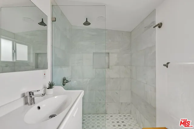 a bathroom with a sink a shower and a mirror