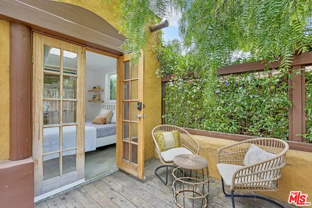 a balcony with couple of chairs and a couch