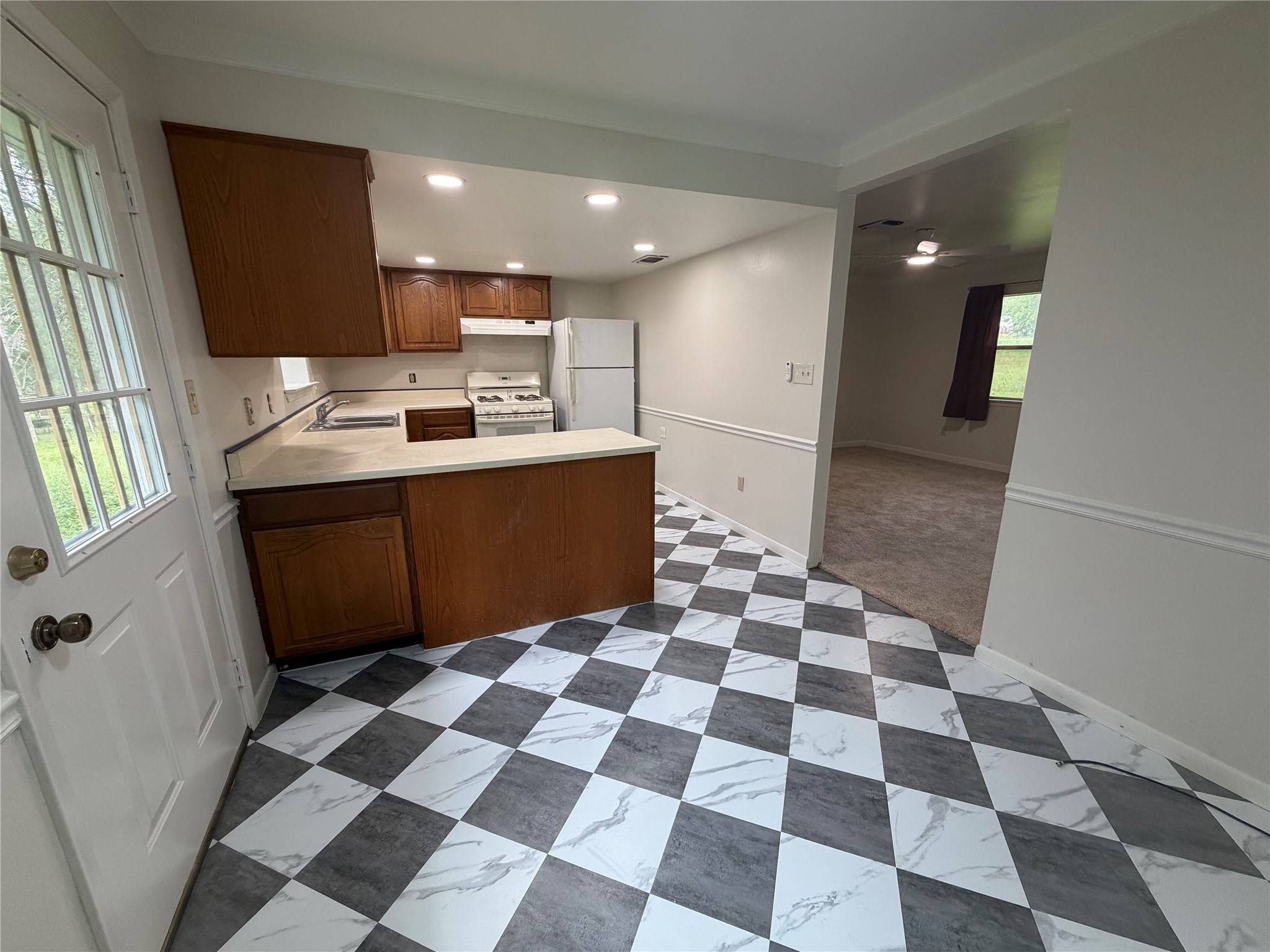 214 The Forest Road Dale, TX 78616 - Photo 7 of 18 Checkerboard flooring guides the eye through this kitchen with ample counter space and storage.
