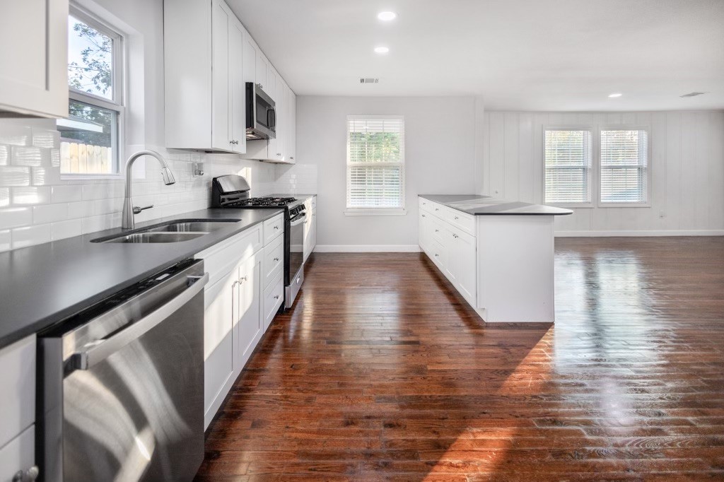 3234 Berry Street Houston, TX 77004 - Photo 13 of 34 a kitchen with granite countertop wooden floors and wide window