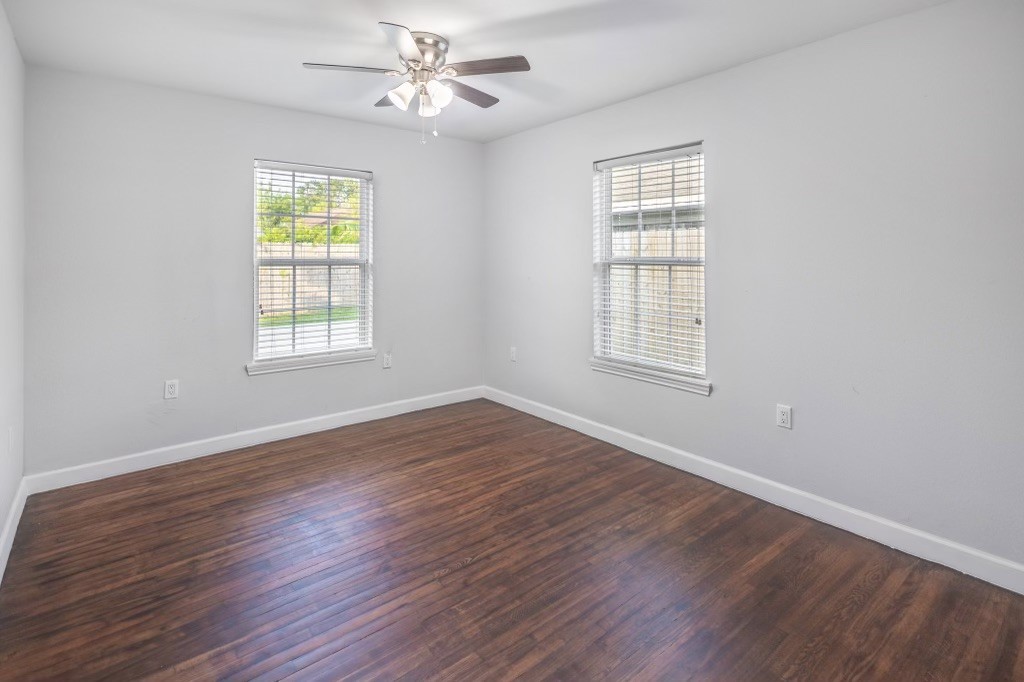 3234 Berry Street Houston, TX 77004 - Photo 26 of 34 an empty room with wooden floor ceiling fan and windows
