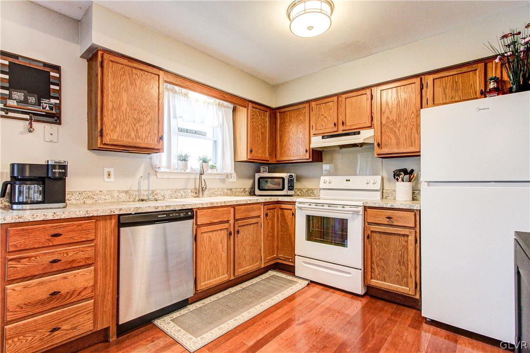 2023 Clover Mill Road Quakertown, PA 18951 - Photo 17 of 48 a kitchen with stainless steel appliances granite countertop a refrigerator a sink dishwasher a stove and white countertops with wooden floor