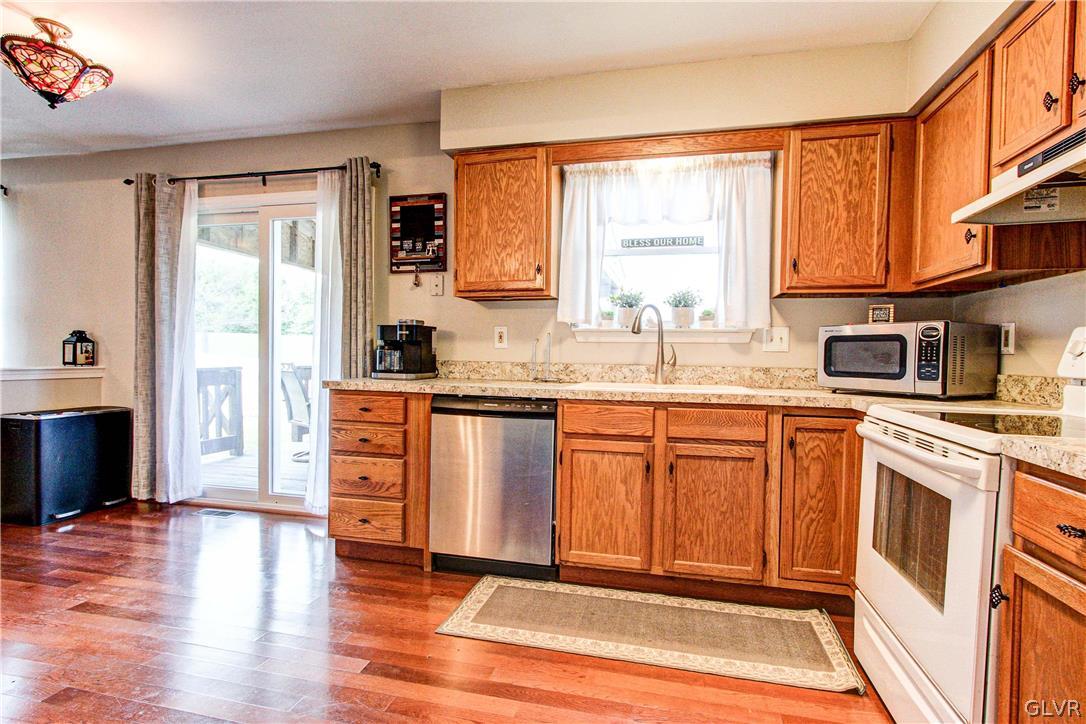 2023 Clover Mill Road Quakertown, PA 18951 - Photo 19 of 48 a kitchen with stainless steel appliances granite countertop a refrigerator a sink dishwasher a stove with wooden cabinets and wooden floor