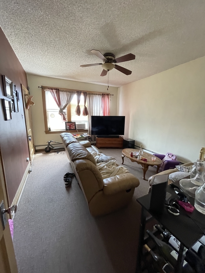 4754 South Springfield Avenue Chicago, IL 60632 - Photo 5 of 12 a living room with furniture a window and a flat screen tv
