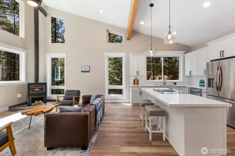 a living room with stainless steel appliances kitchen island granite countertop furniture and a large window