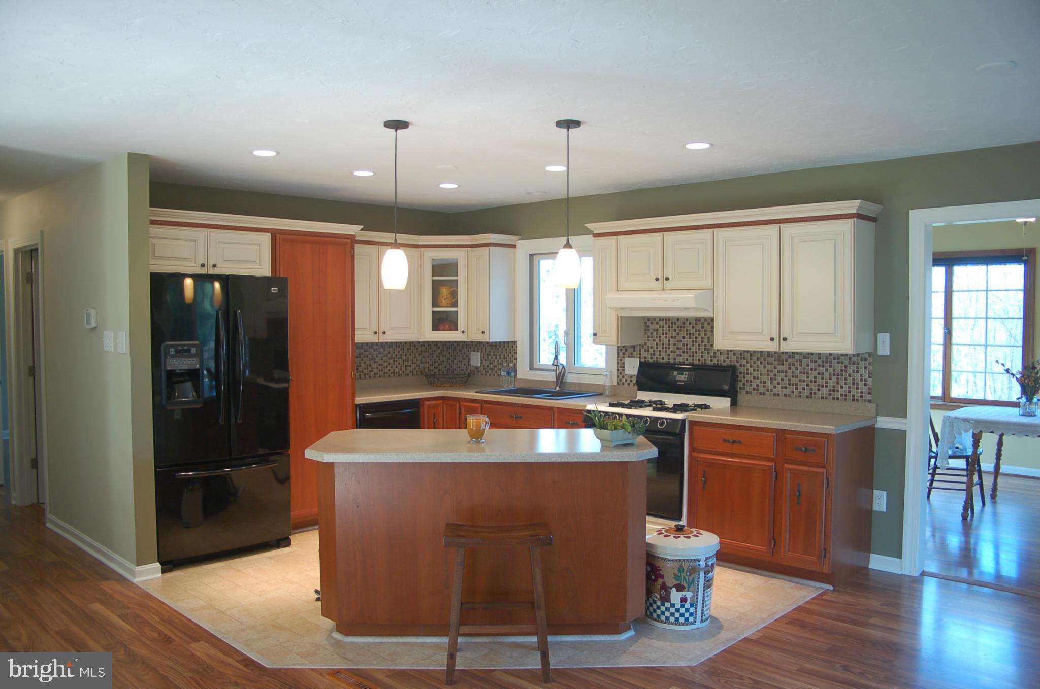 2684 Mt Ventus Road Manchester, MD 21102 - Photo 2 of 23 a large kitchen with stainless steel appliances granite countertop a refrigerator a sink dishwasher a stove and a dining table with wooden floor