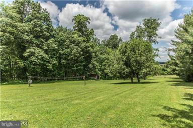 2684 Mt Ventus Road Manchester, MD 21102 - Photo 22 of 23 a view of a grassy field with trees in the background