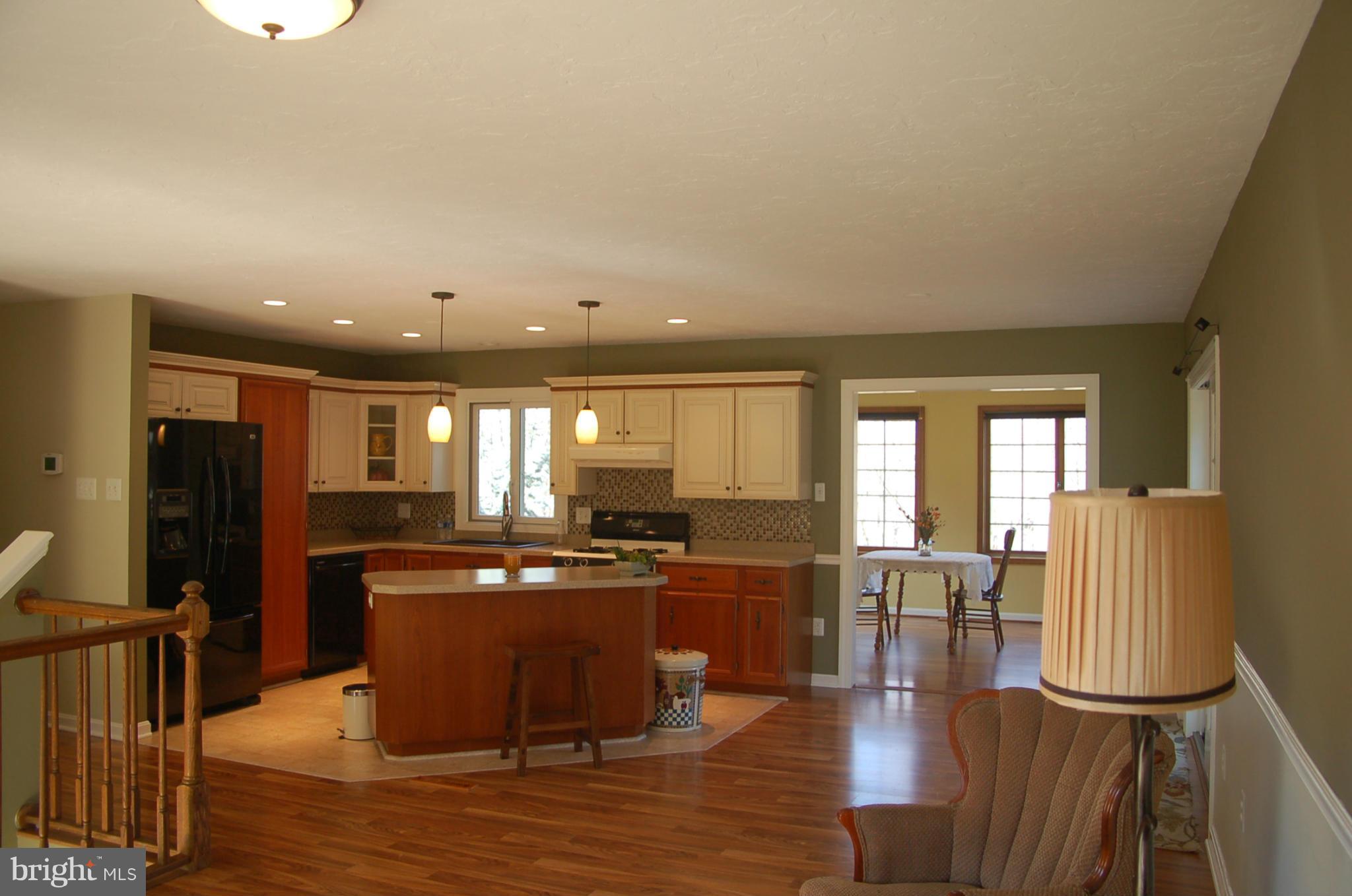 2684 Mt Ventus Road Manchester, MD 21102 - Photo 8 of 23 a kitchen with stainless steel appliances granite countertop a refrigerator a sink dishwasher a stove and a dining table with wooden floor