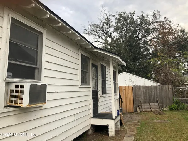 a view of a chair and table in backyard of the house