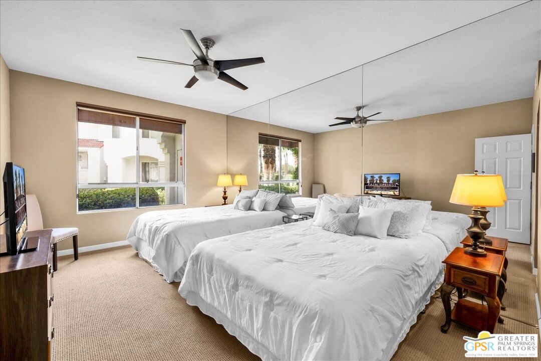 401 El Cielo Road, Unit 147 Palm Springs, CA 92262 - Photo 19 of 44 a bedroom with a bed and a chandelier