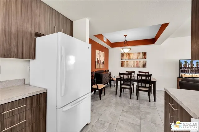 a view of a kitchen with dining area a sink and a refrigerator