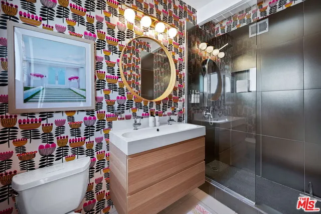 a bathroom with a sink a toilet and shower
