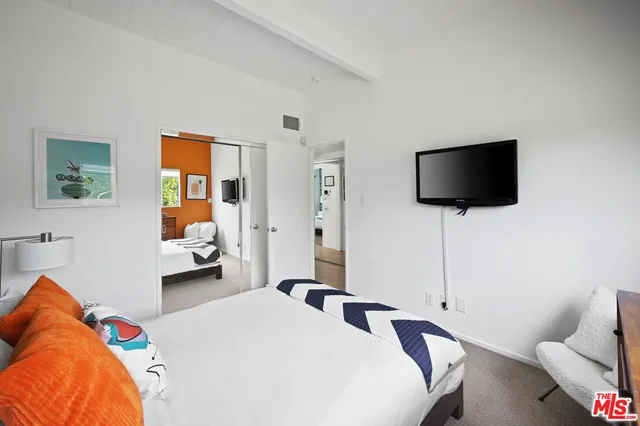 a bedroom with a bed and a flat screen tv