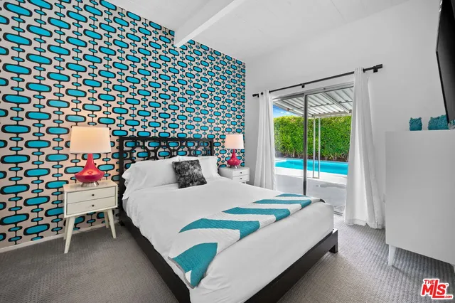 a bedroom with a bed and a lamp next to a window