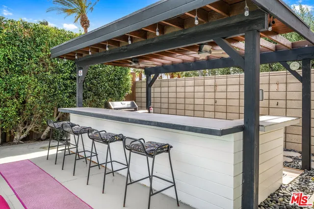 a patio with wooden floor a yard table and chairs